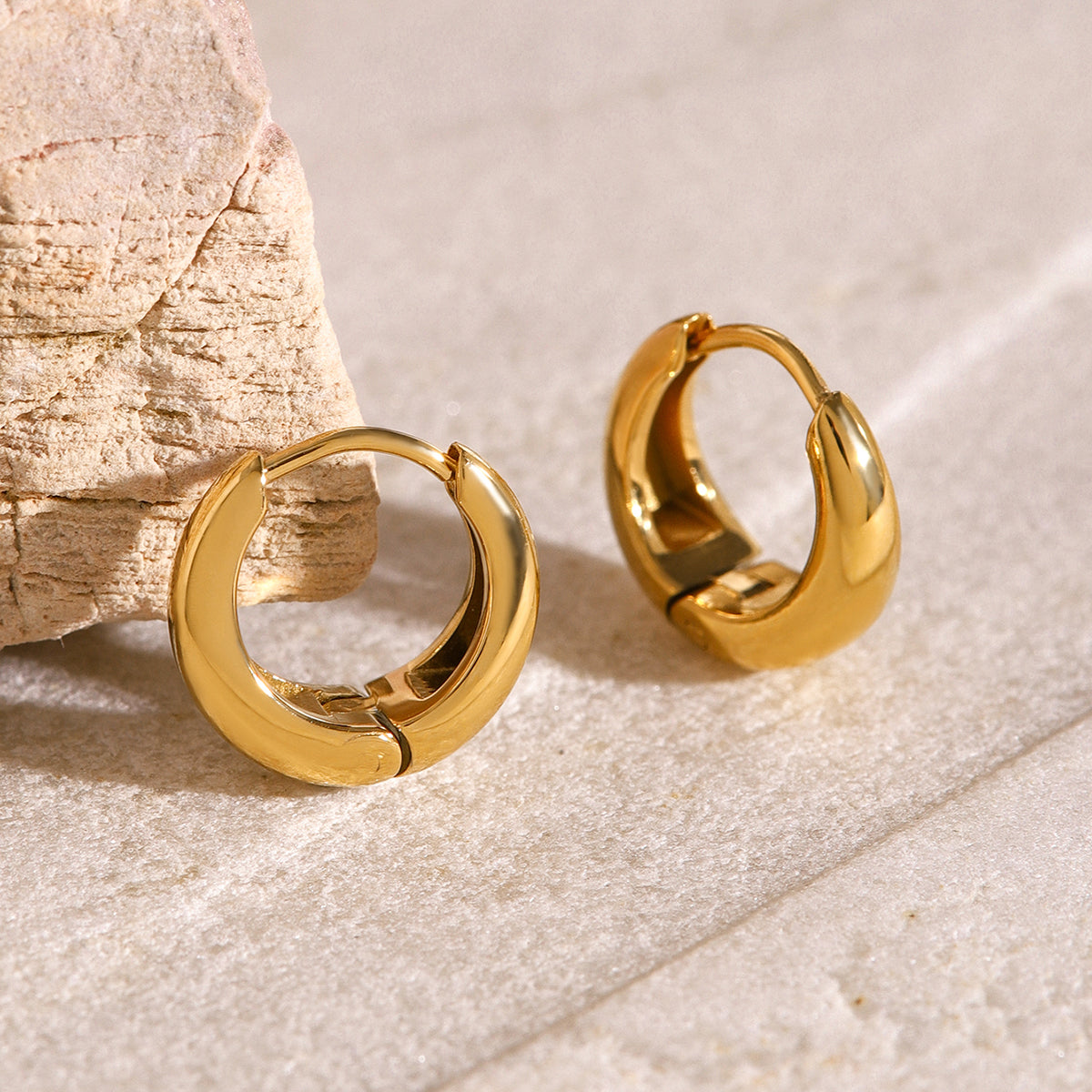 Iris – Aros geométricos huggie de oro