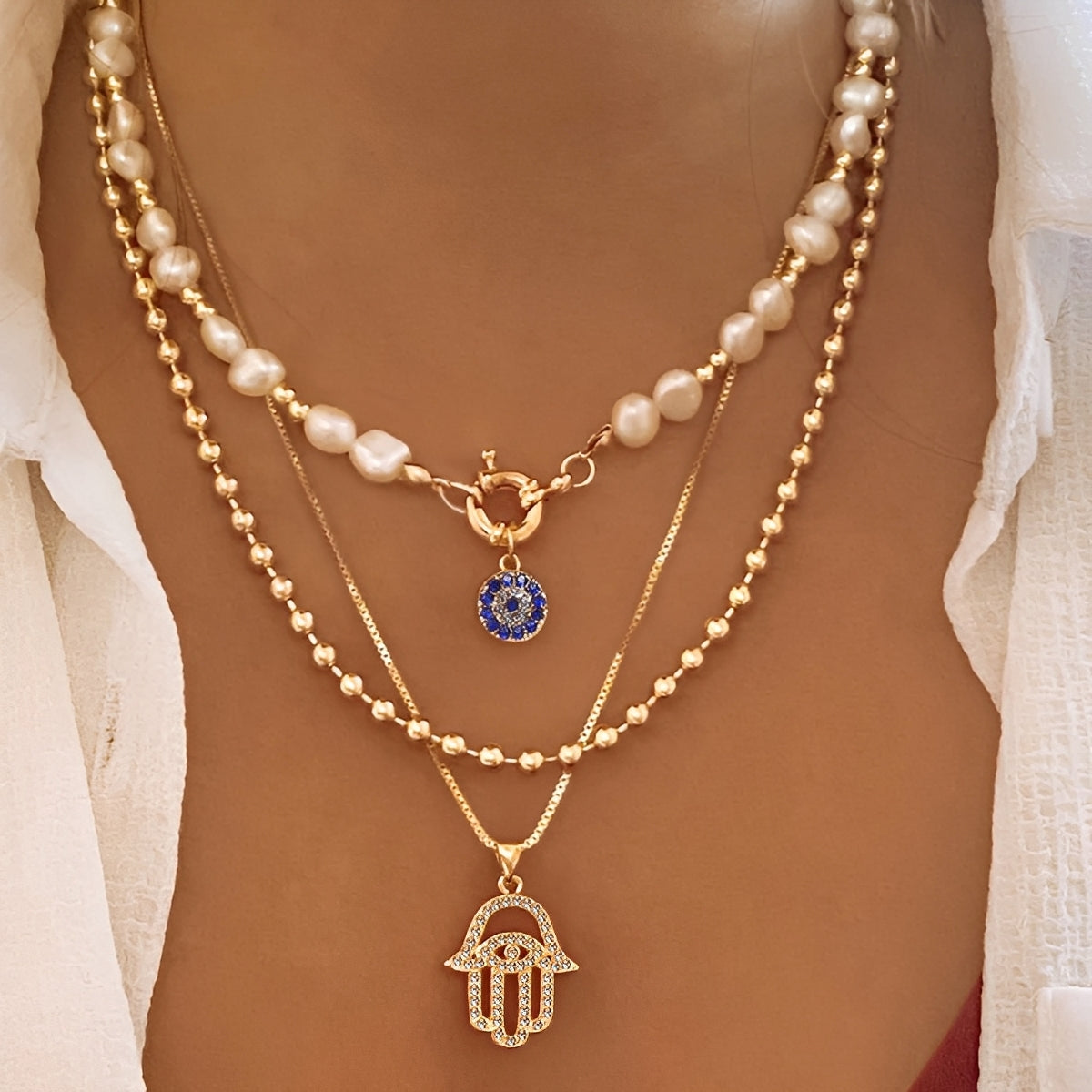Nadia – Collar con varias filas de perlas y mano de Hamsa