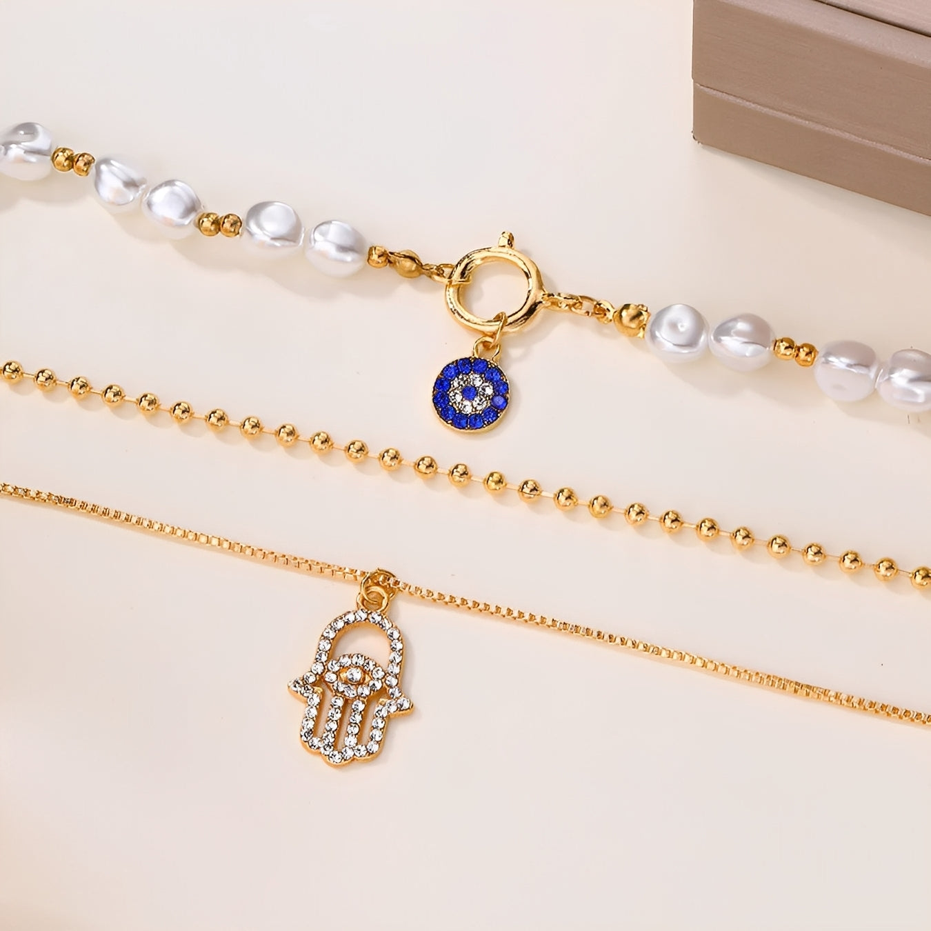 Nadia – Collar con varias filas de perlas y mano de Hamsa