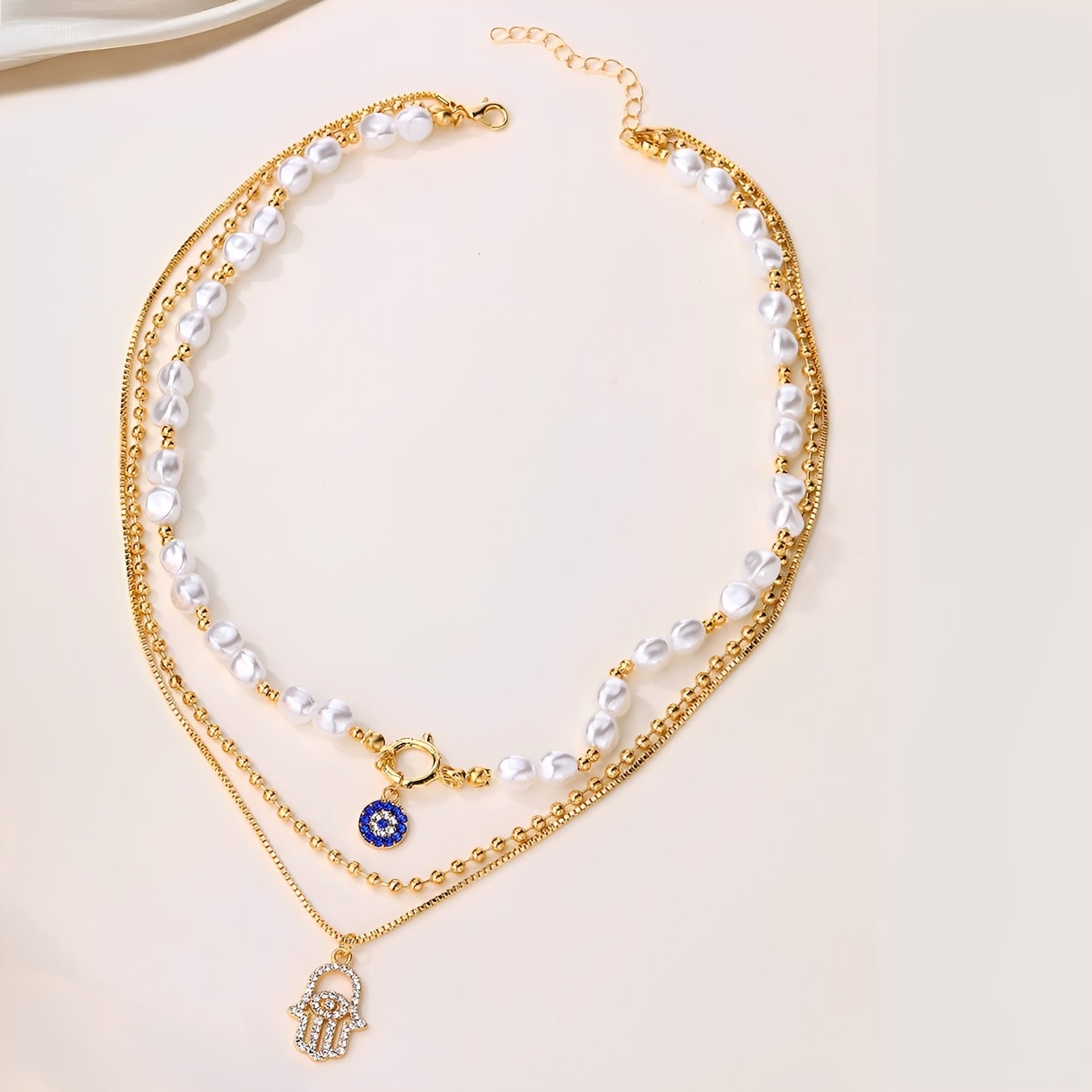 Nadia – Collar con varias filas de perlas y mano de Hamsa